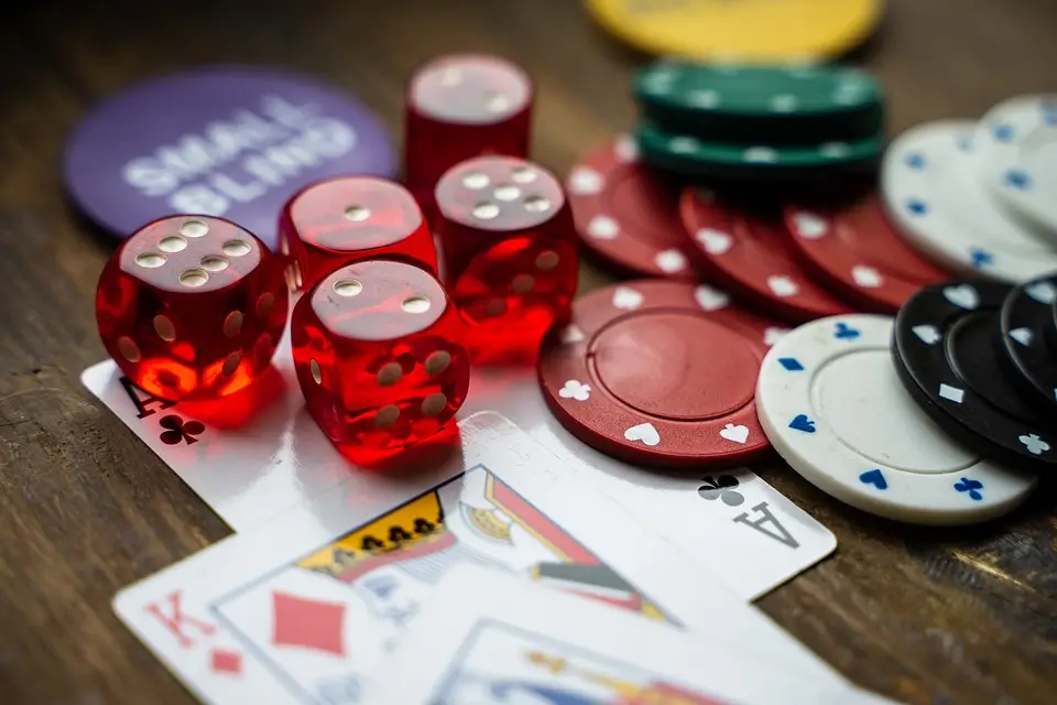 A close-up of a casino table featuring poker chips, cards, and dice