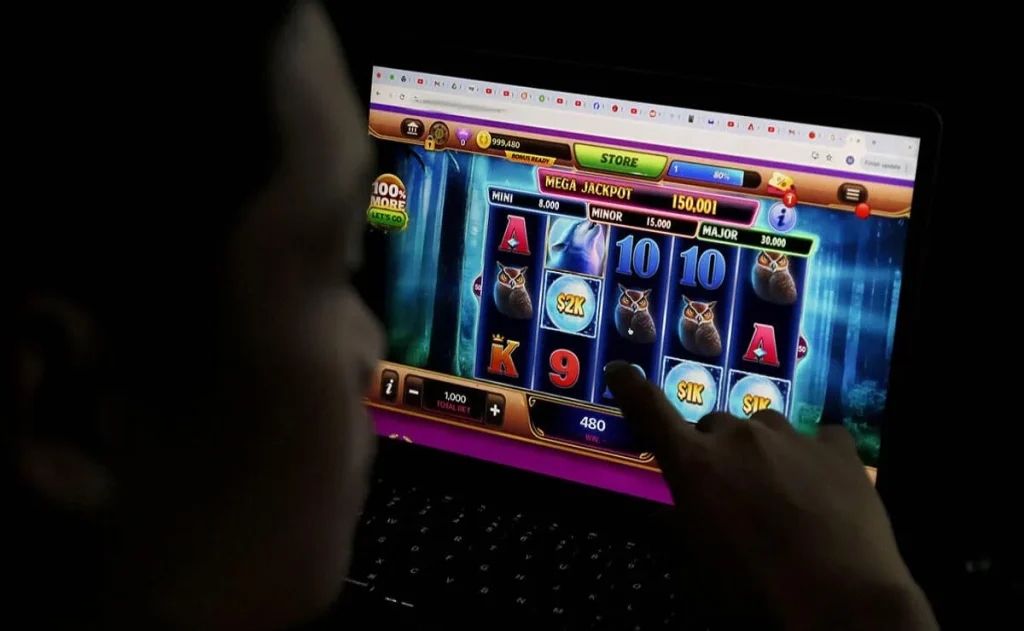 A player using a laptop to enjoy a slot machine game